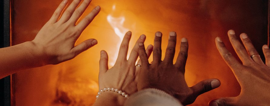 Hænder varmer på pejsen