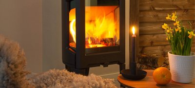 Jøtul F 163 sort brændeovn med påskeliljer i hytte