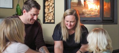 Karoline og familien sidder og spiller spil foran Jøtul I 620 FR pejseindsatsen