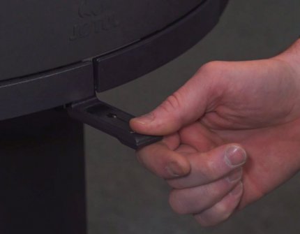 Hånd der regulerer lufttilførslen i pejsen