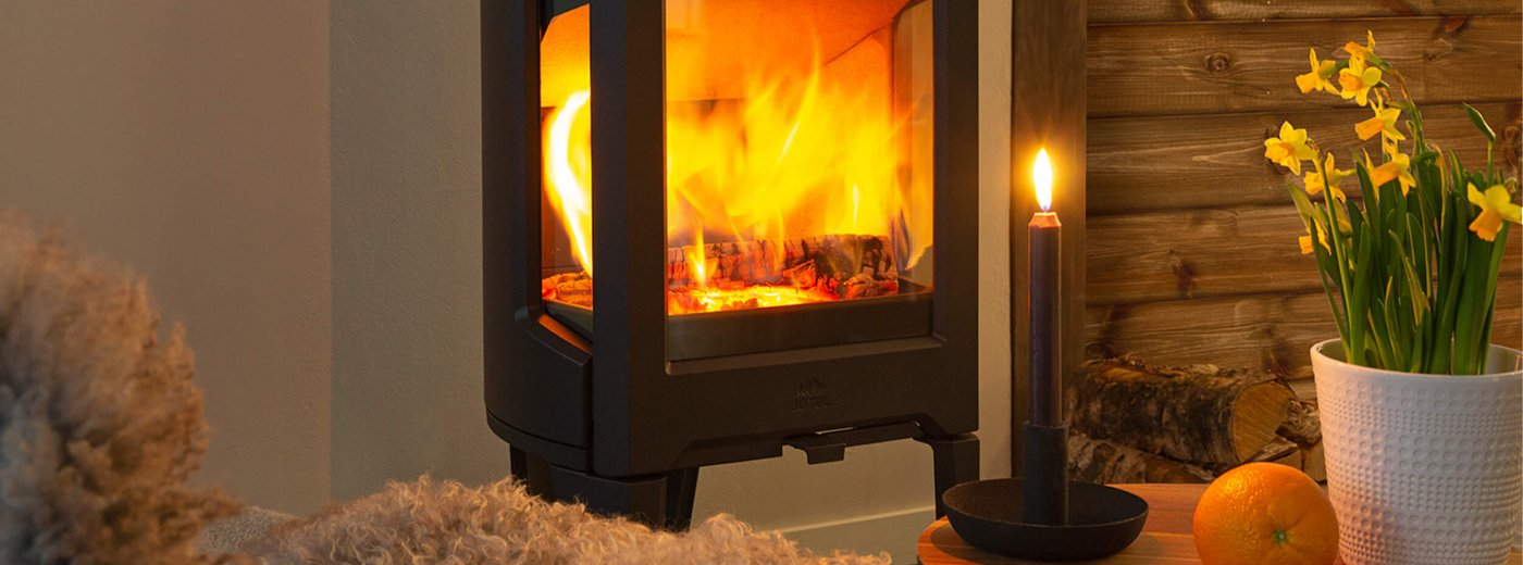 Jøtul F 163 sort brændeovn med påskeliljer i hytte