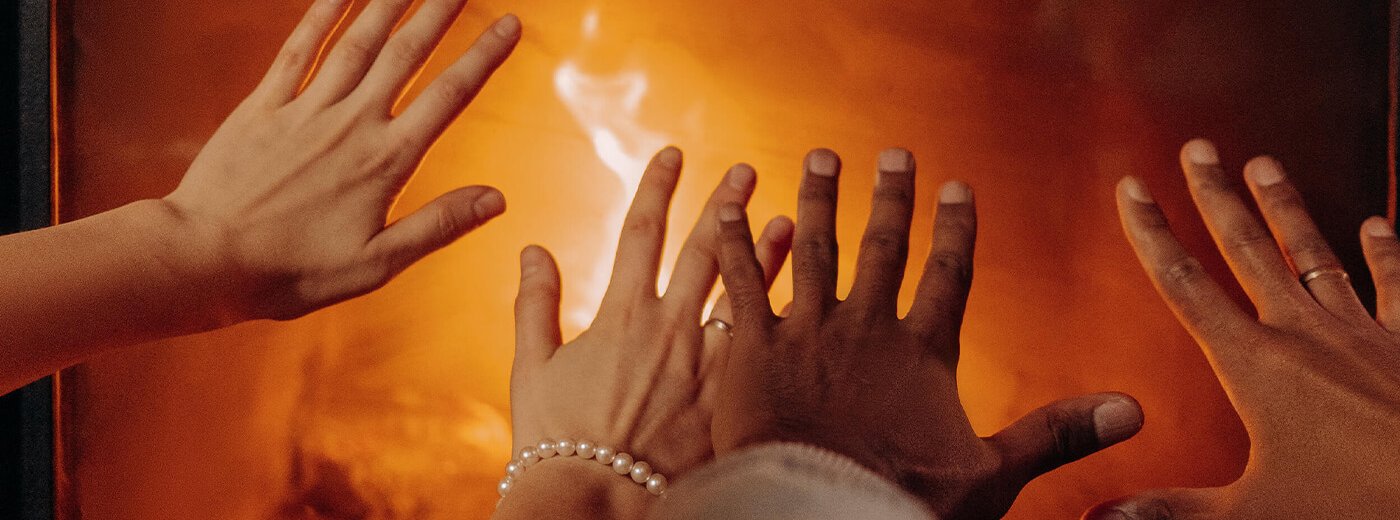 Hænder varmer på pejsen