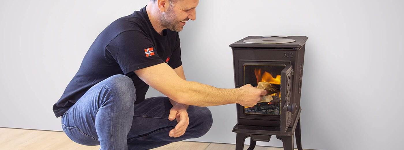 mand putter træ i Jotul F 602 ECO brændeovnen