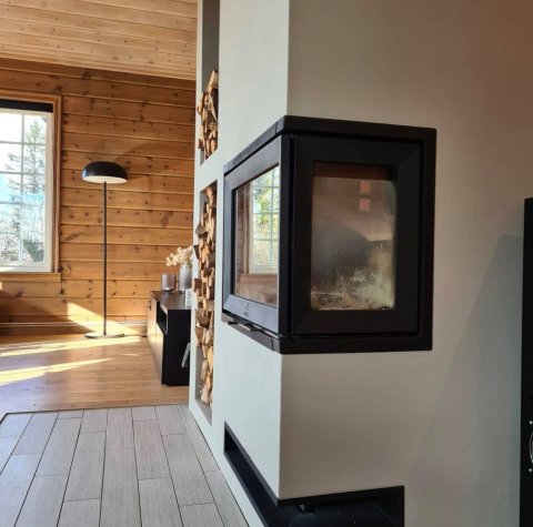 Hvid omramning med sort træindsats kaldet Jøtul I 520 FR i en norsk hytte.