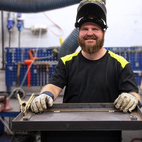Mand der arbejder på Jøtul fabrik med værksted bag sig.